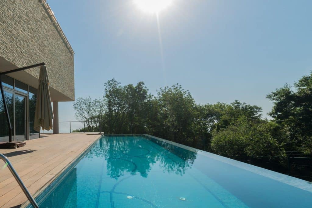 Piscine à débordement avec terrasse en bois