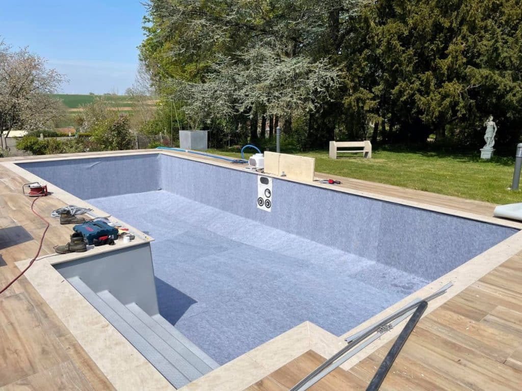 Pose d'un feutre de protection pour le remplacement d'un liner sur une piscine enterrée