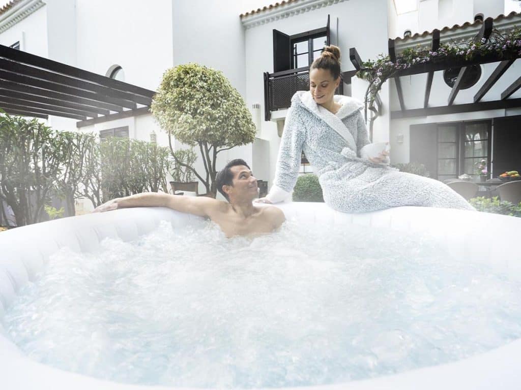 Couple profitant d'un spa gonflable chauffé en hiver